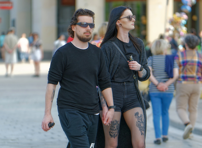 14 - Couple walking hand-in-hand down a public street